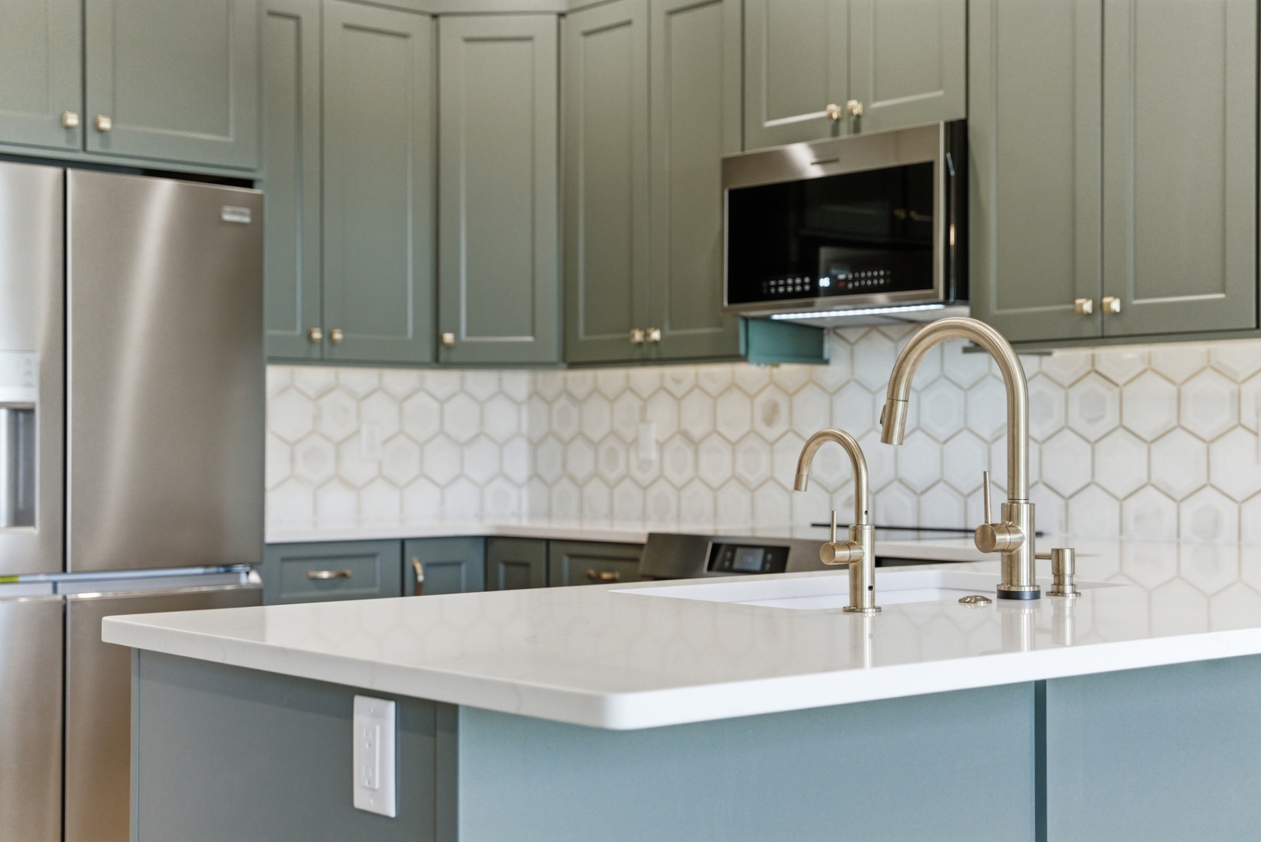 Finished Waterloo kitchen island with double brushed-nickel faucets and hexagon backsplash