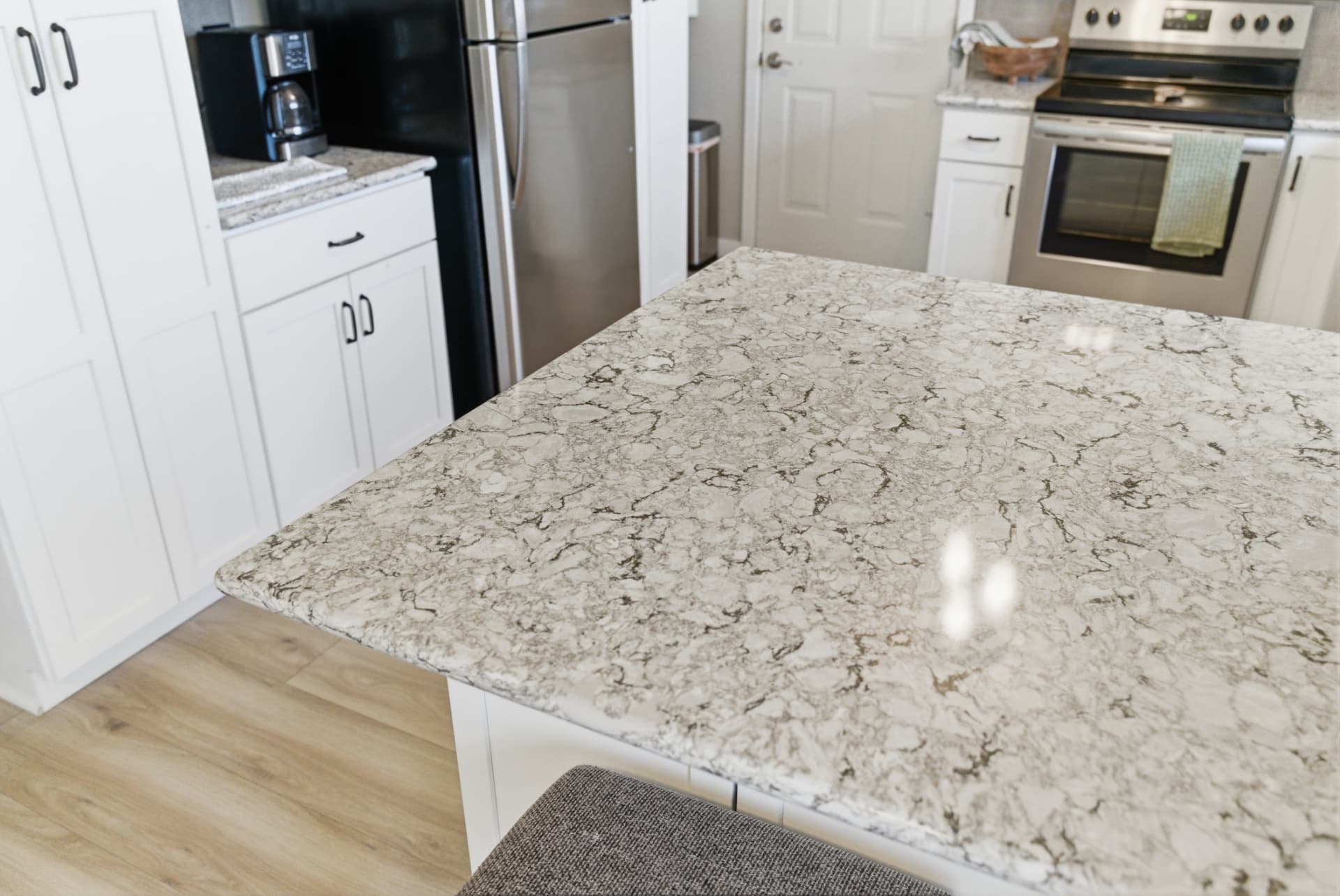 Close view of the finished patterned kitchen island countertop with white cabinetry behind it