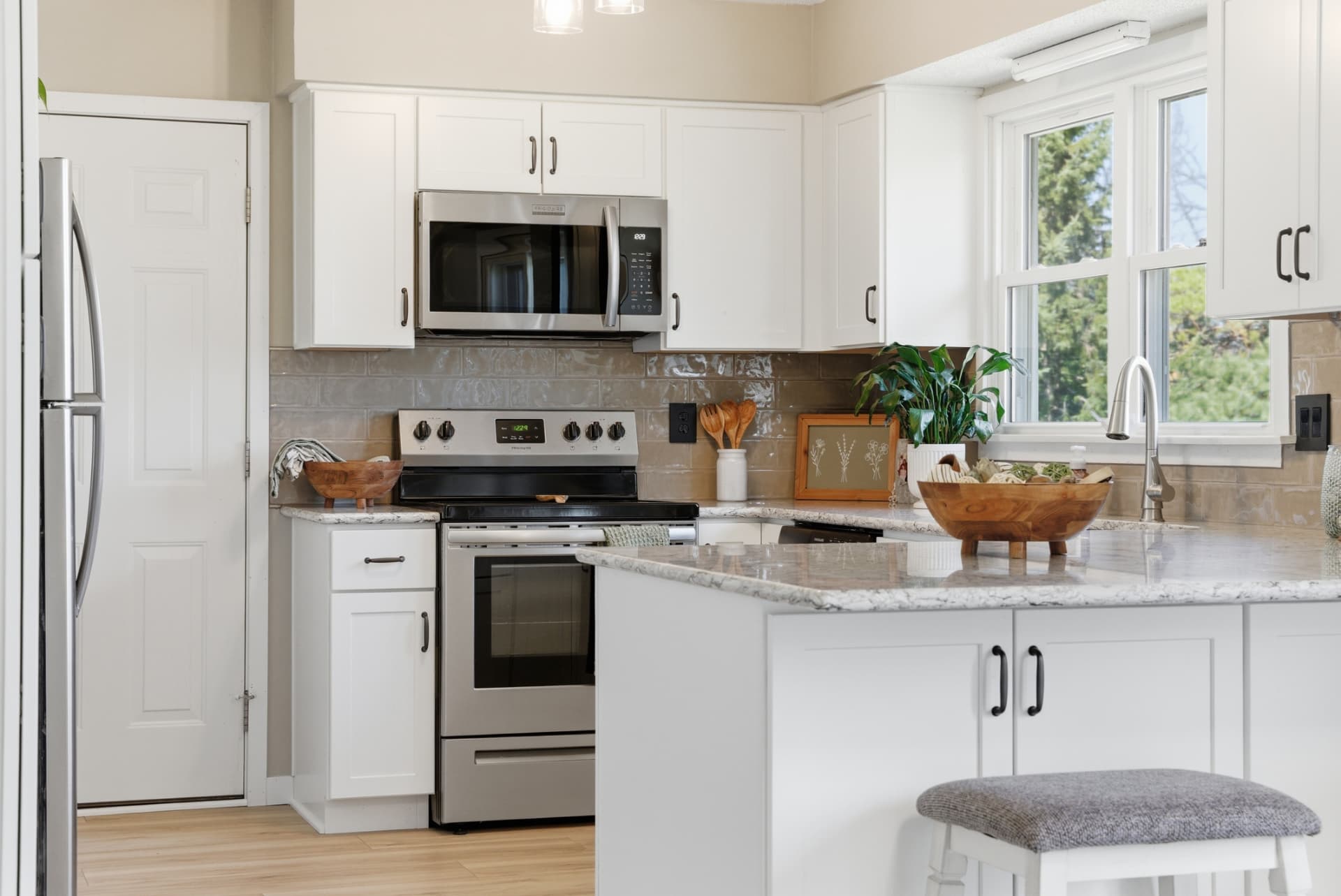 Finished Cedar Falls, Iowa kitchen refresh with white cabinets, island and new flooring