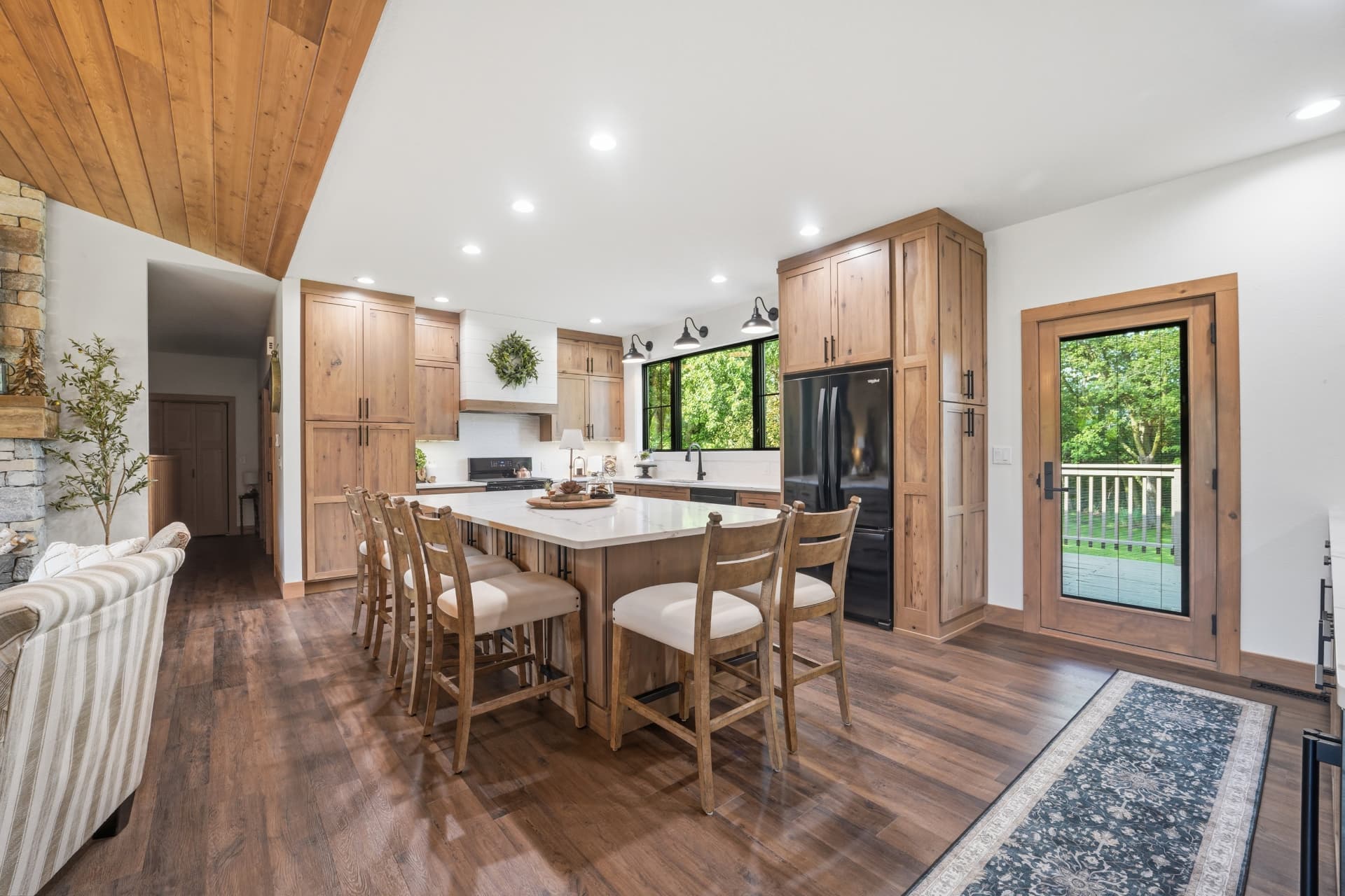 Open-concept kitchen with island seating and wood-framed patio entry door