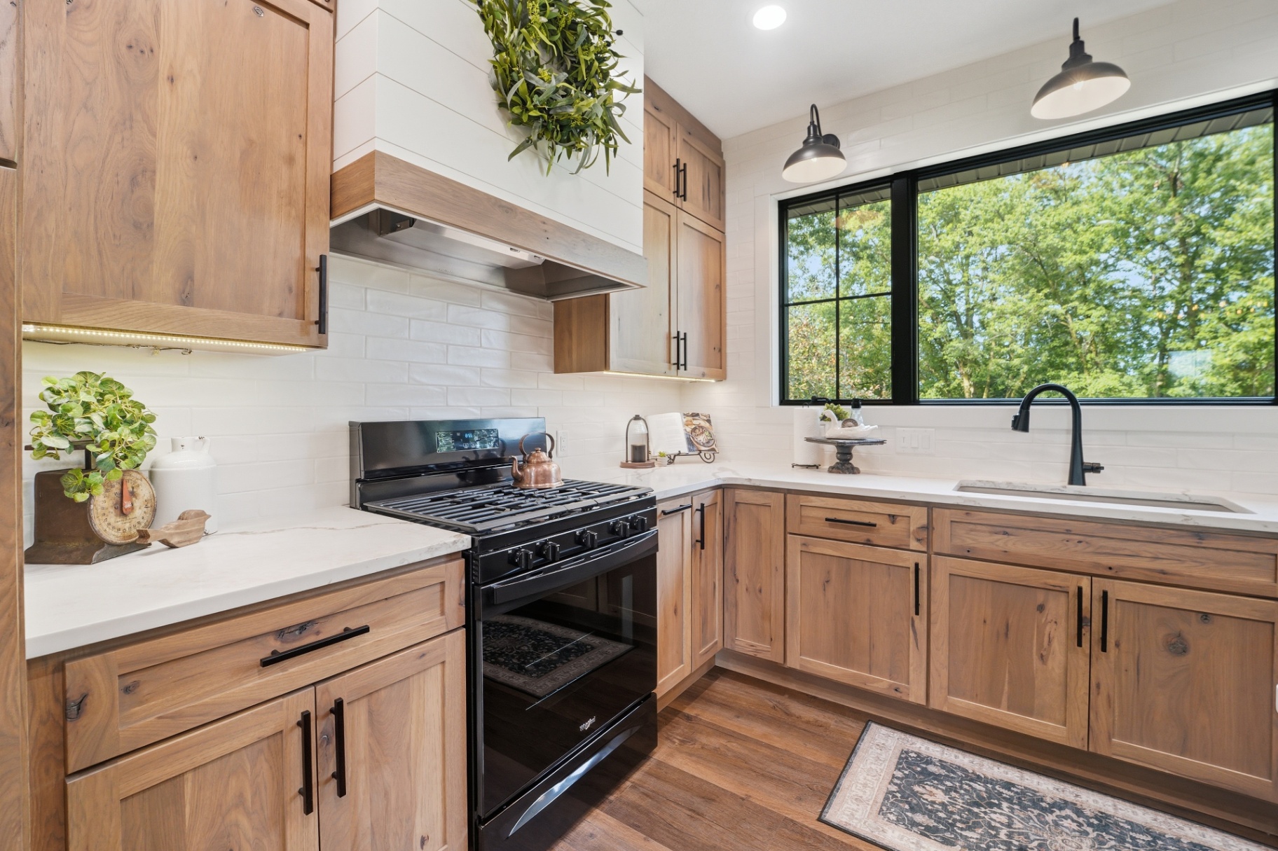 Rustic hickory range wall with custom wood hood and window sink beyond