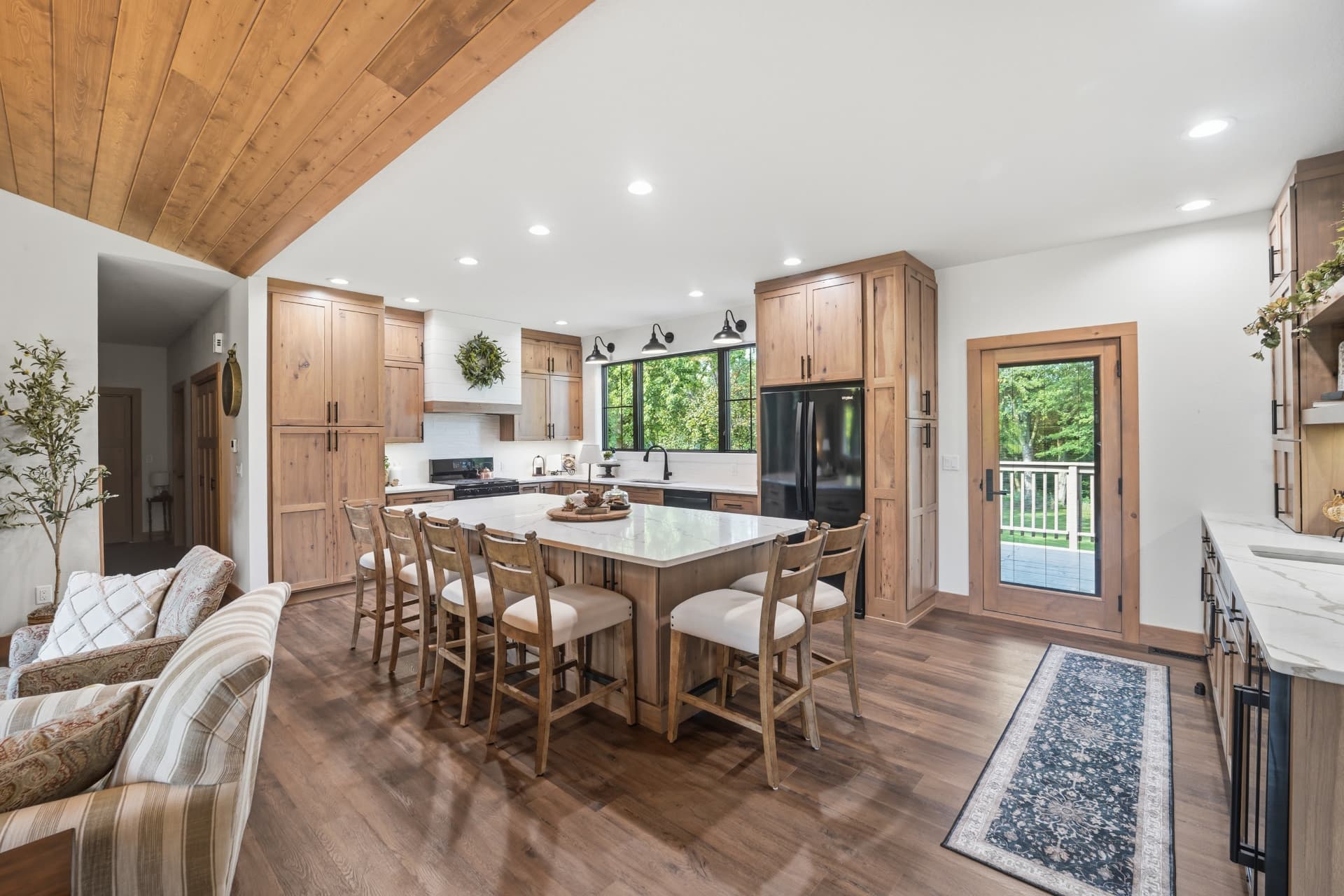 Large quartz kitchen island with seating beneath a vaulted wood ceiling in Gladbrook Iowa