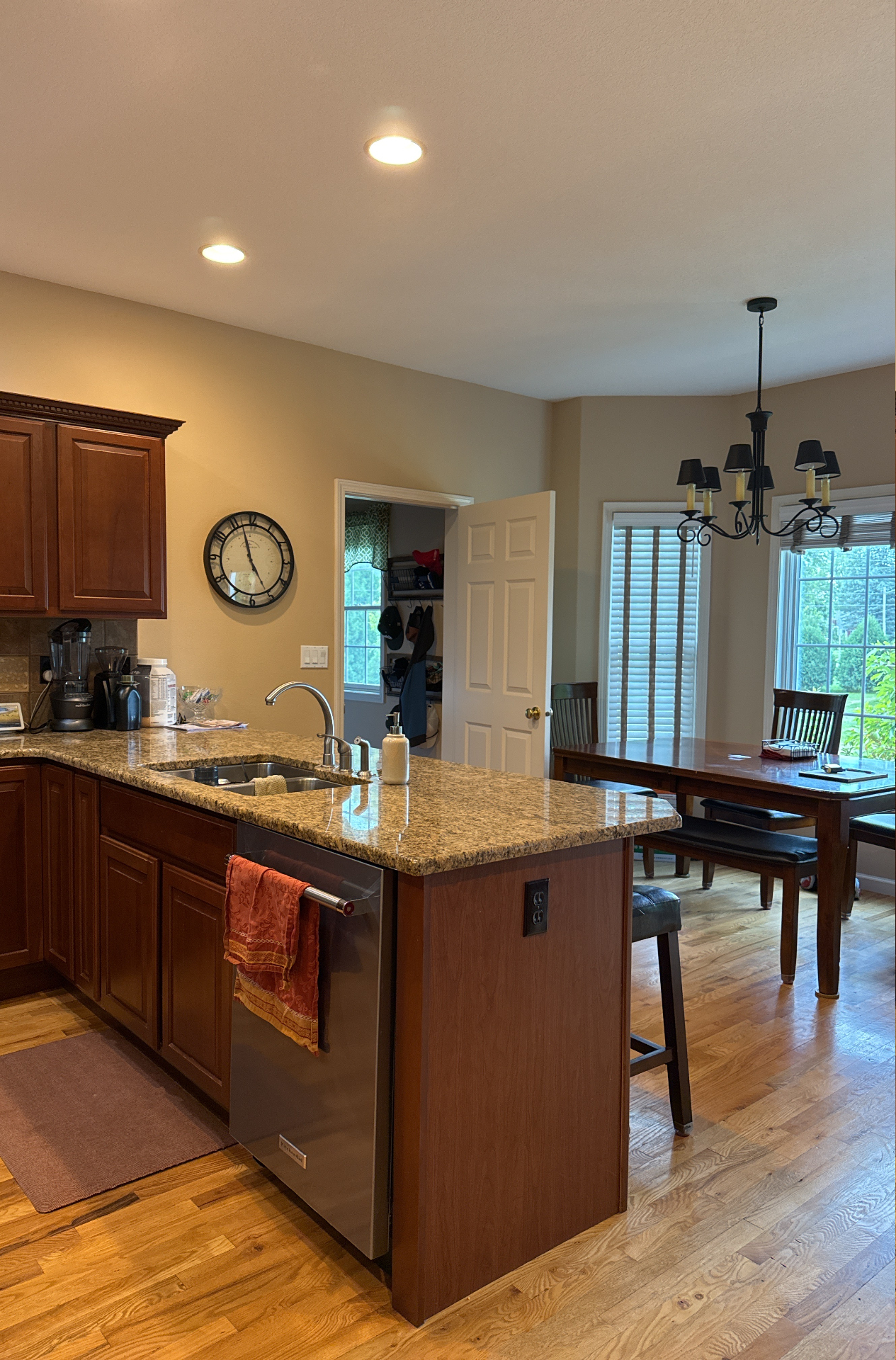 Waterloo kitchen before renovation with darker wood cabinetry, granite countertops, and adjoining dining area