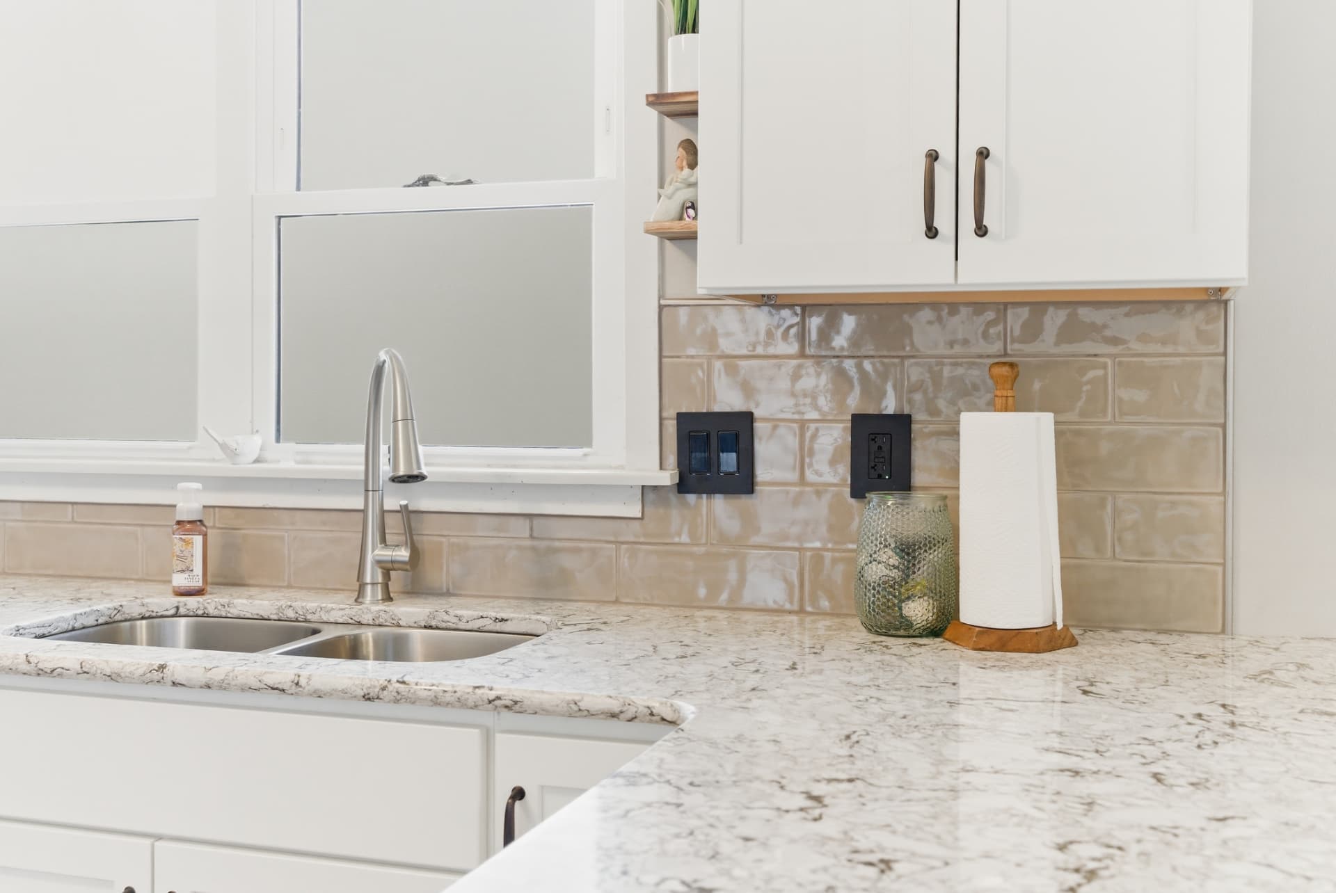 Finished glossy tile backsplash above the sink and patterned countertop