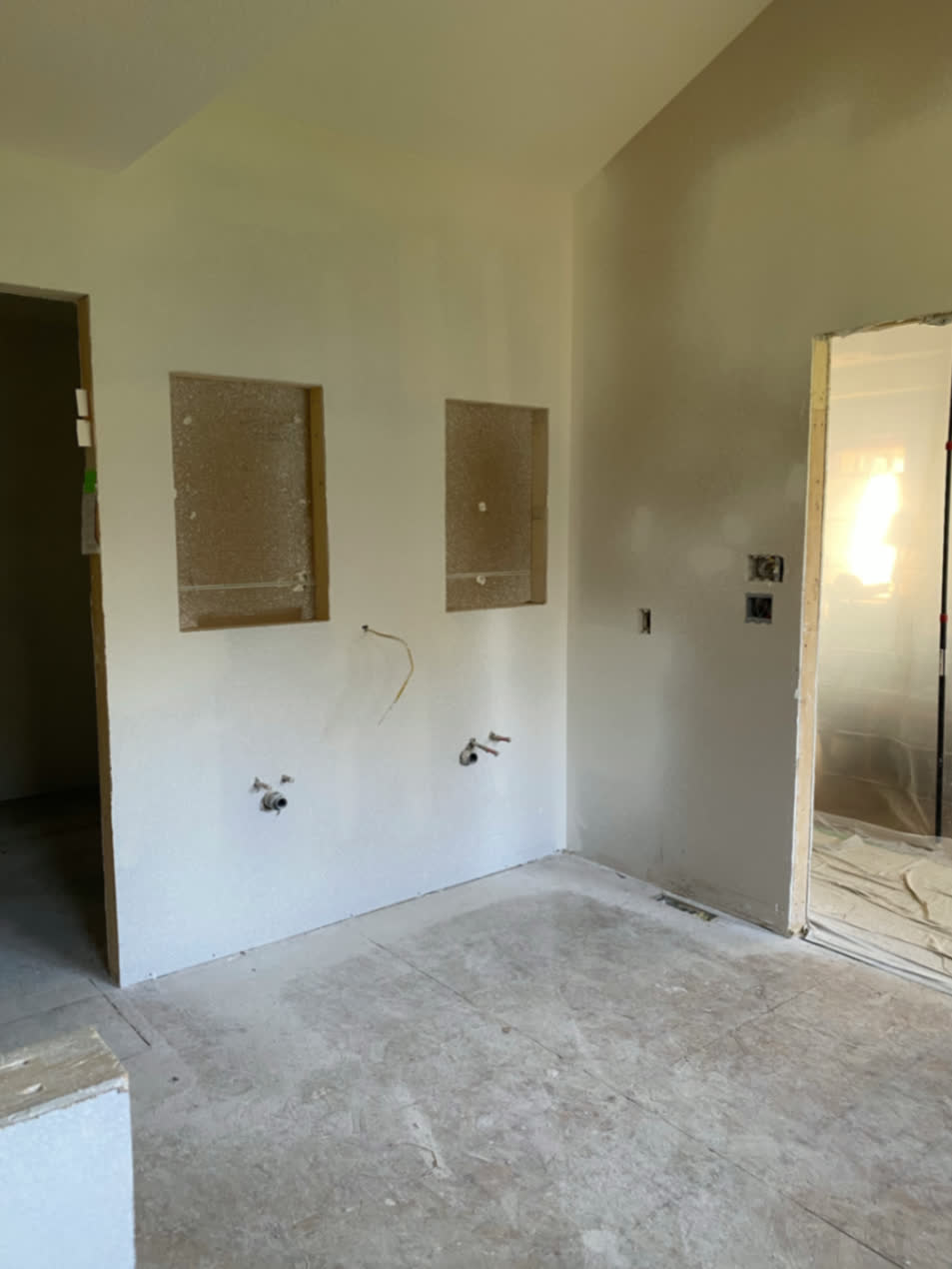 Bathroom vanity wall during construction with drywall work and electrical rough-ins visible