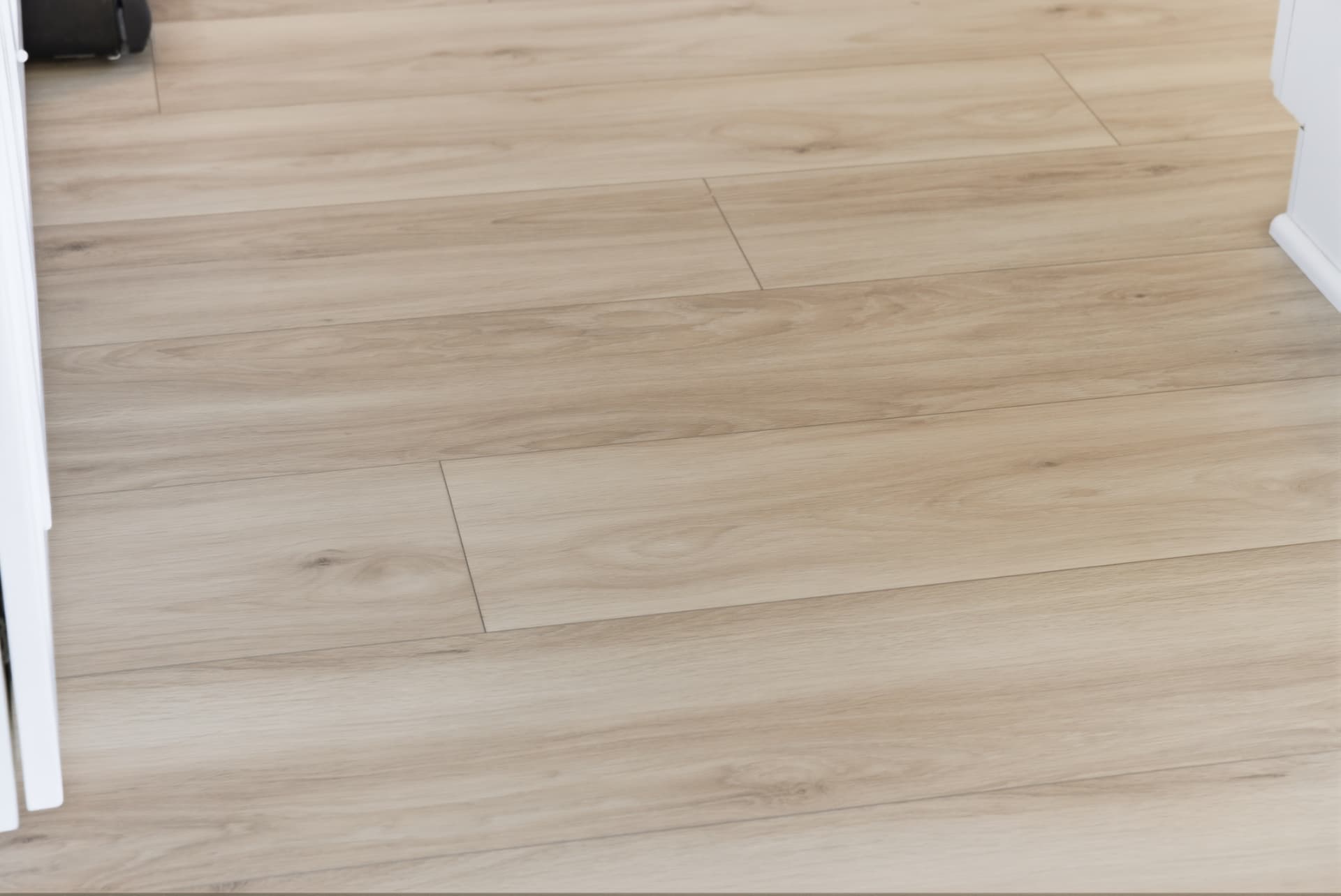 Close view of the finished light wood-look plank flooring in the Cedar Falls kitchen