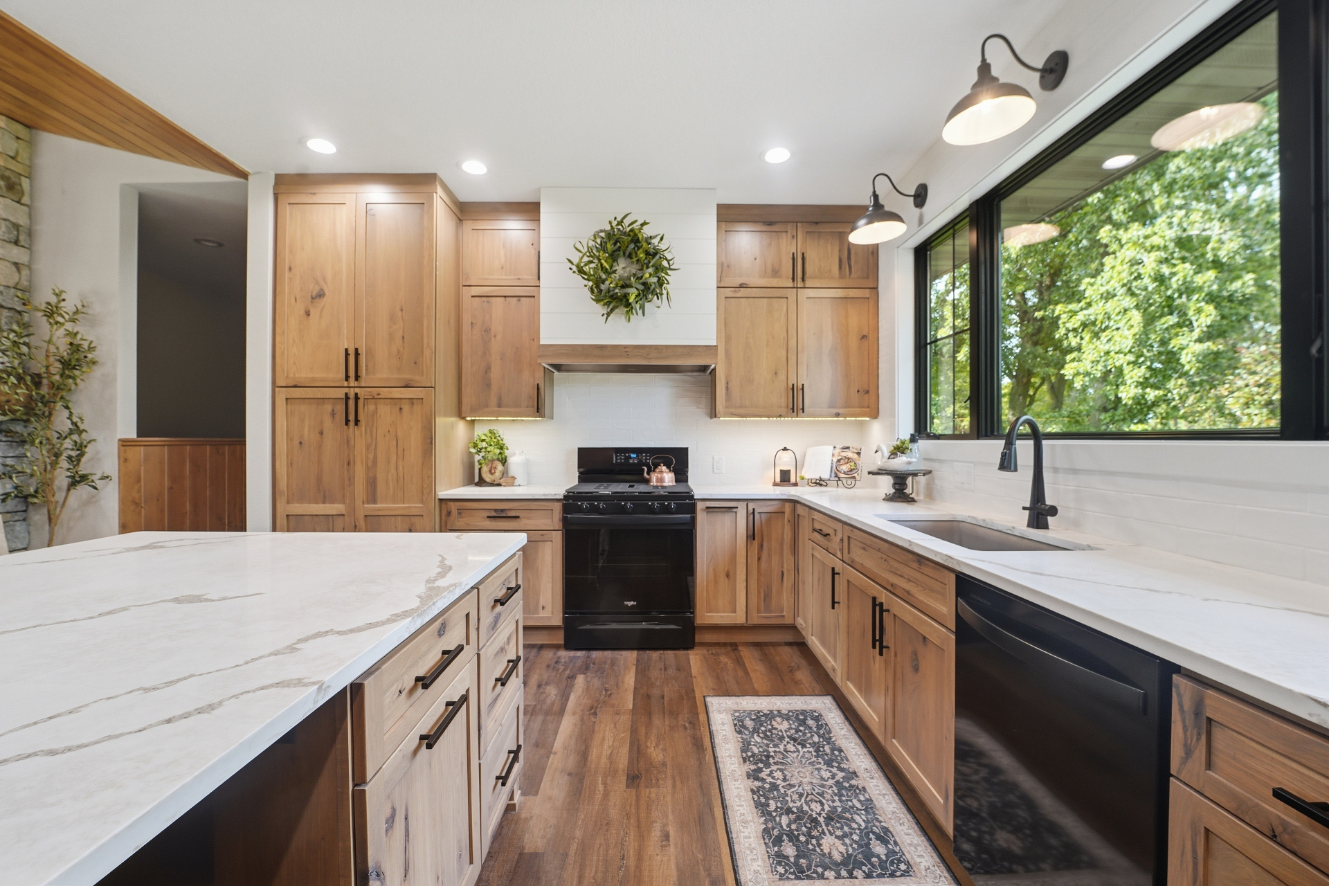 Finished Gladbrook, Iowa kitchen with hickory cabinets, custom wood range hood and quartz island