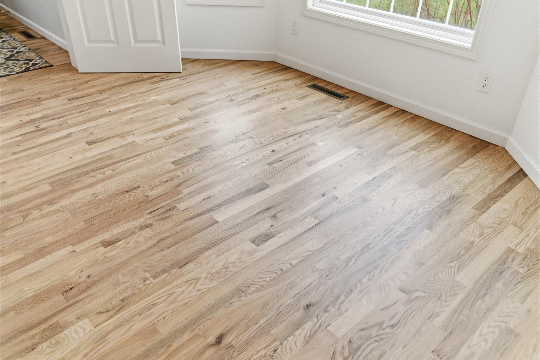 Refinished red oak hardwood flooring in the Waterloo dining area after sanding and finishing