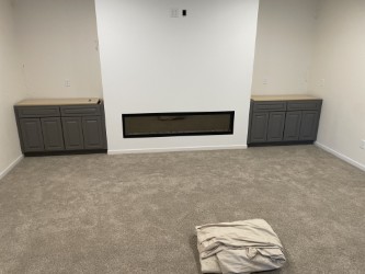 Carpet installation around a modern fireplace in Cedar Falls Iowa