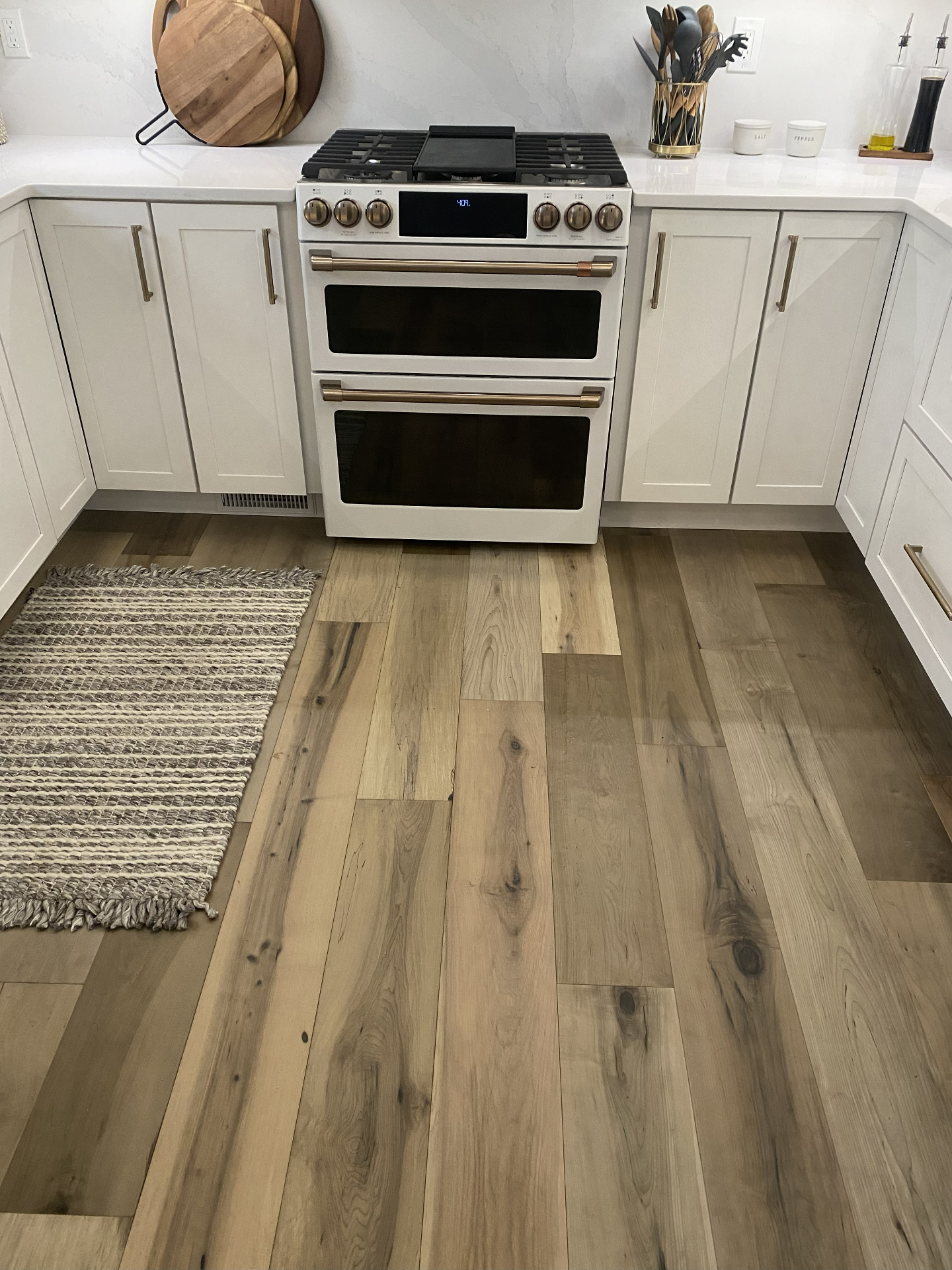 Hardwood flooring in a white kitchen with brass fixtures in Iowa